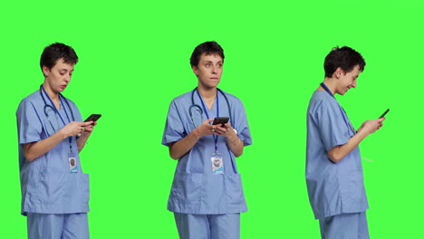 Junge-Krankenschwester-Schreibt-SMS-Auf-Smartphone-Vor-Greenscreen-Hintergrund